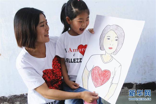 5月10日，在河北唐山市豐潤區(qū)迎賓路幼兒園開展的“媽媽，我愛你”主題活動中，陳悅寧小朋友將自己的繪畫作品送給媽媽作為節(jié)日禮物。 新華社發(fā)（朱大勇 攝）