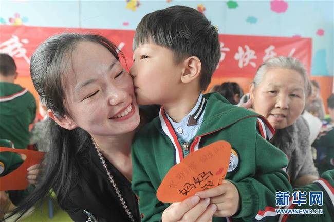 5月10日，在湖北省襄陽市一家幼兒園舉辦的母親節(jié)主題活動中，一名小朋友將自己制作的賀卡獻給媽媽。 新華社發(fā)（安富斌 攝）